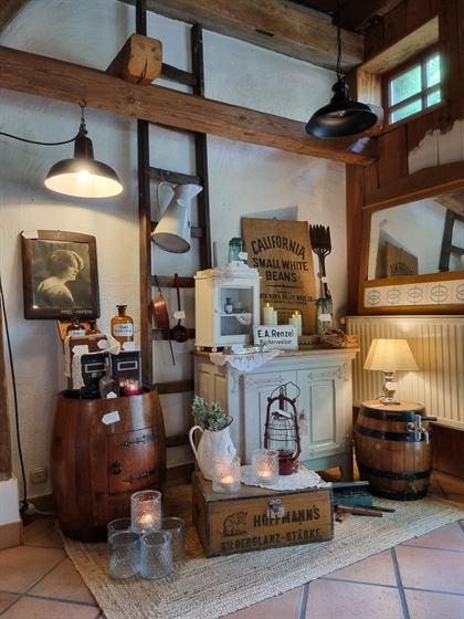 Fachwerk-Ecke mit Holzfass, Apothekerflaschen und alten Werbekisten