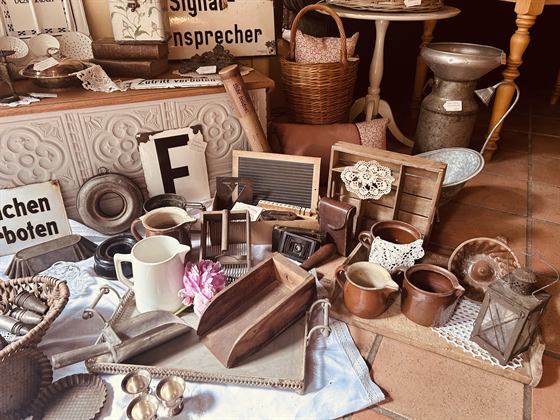 Tablett mit Krügen, alter Kamera und Spitzendeckchen
